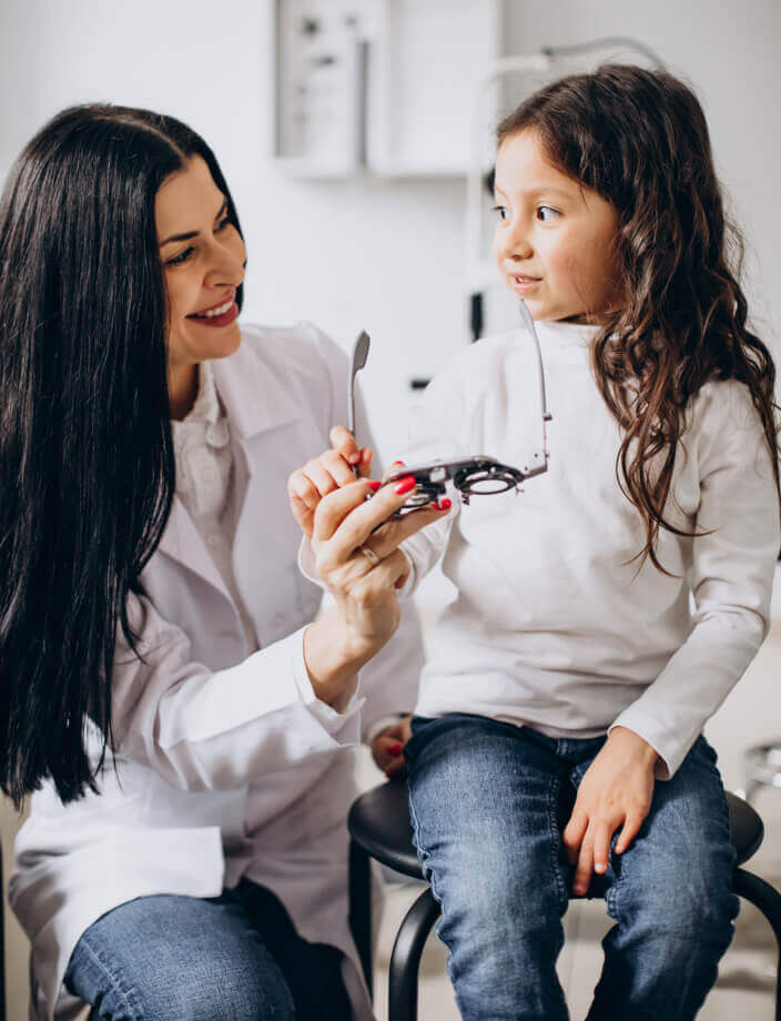 Niña realizándose un examen de la vista con optometrista